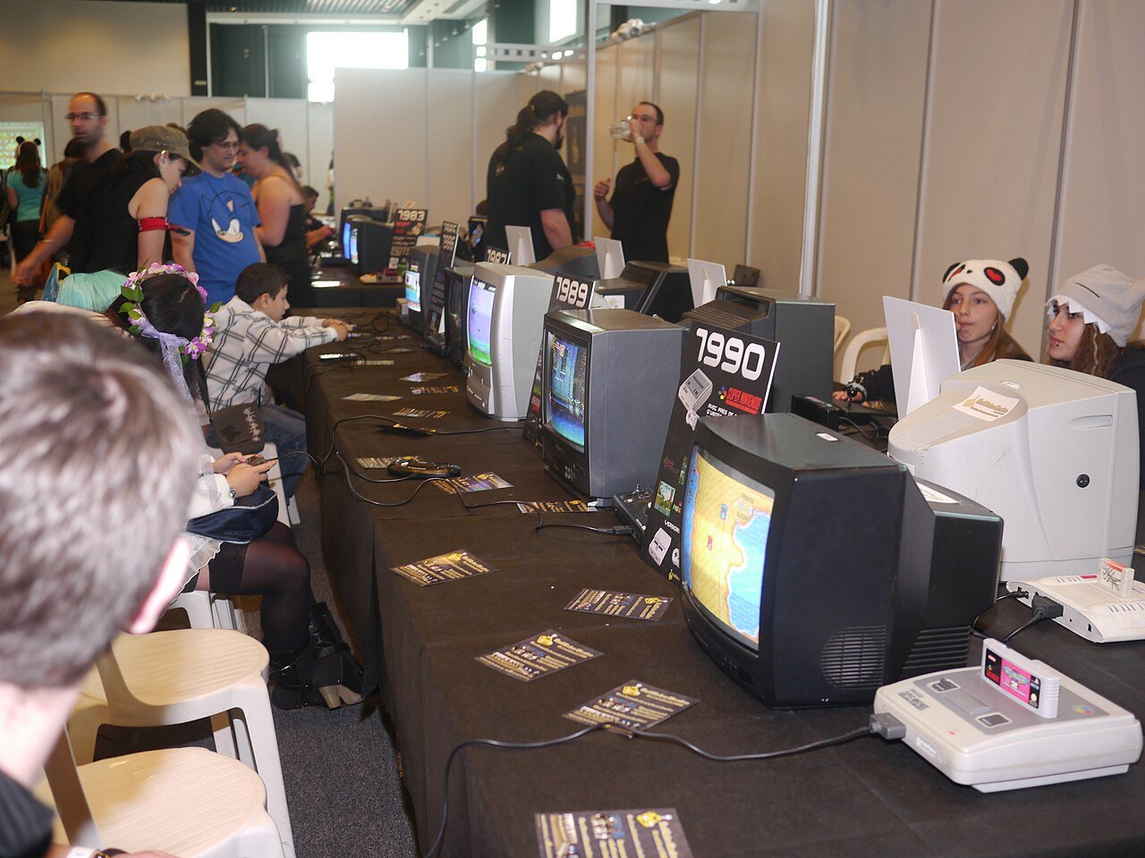Público joga em consoles antigos em área de free play de evento de games retrô (imagem ilustrativa)